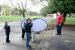 Camera assistant Sam Russell holds a reflector to help properly light Dennis